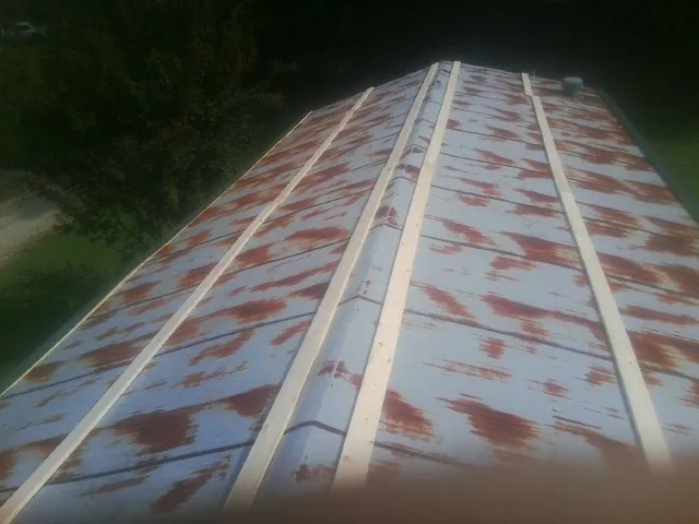 Rusted metal roof panels with new wood purlins before replacement — Storm Damage Roof Repair in Indian Rocks Beach by Roofing Brothers