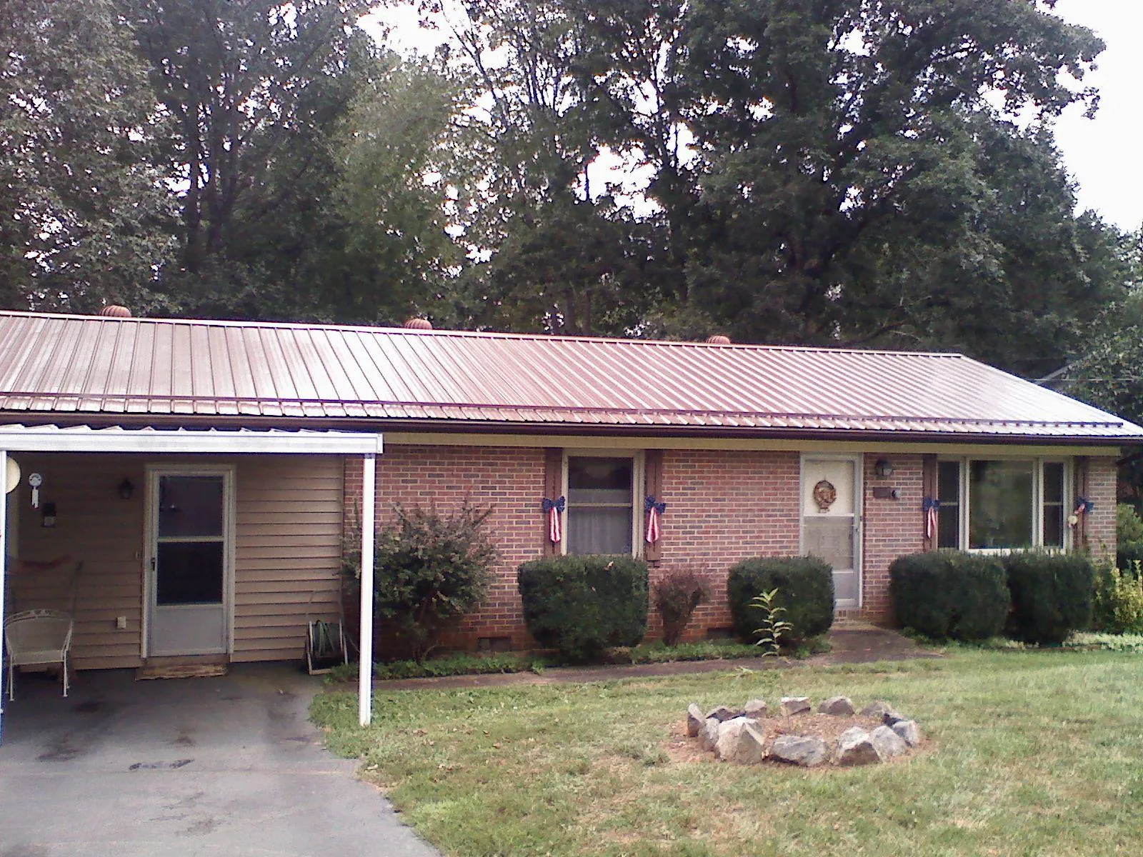 Bronze metal roof and carport on a brick ranch home — Roof Repair work by our crew in Indian Rocks Beach